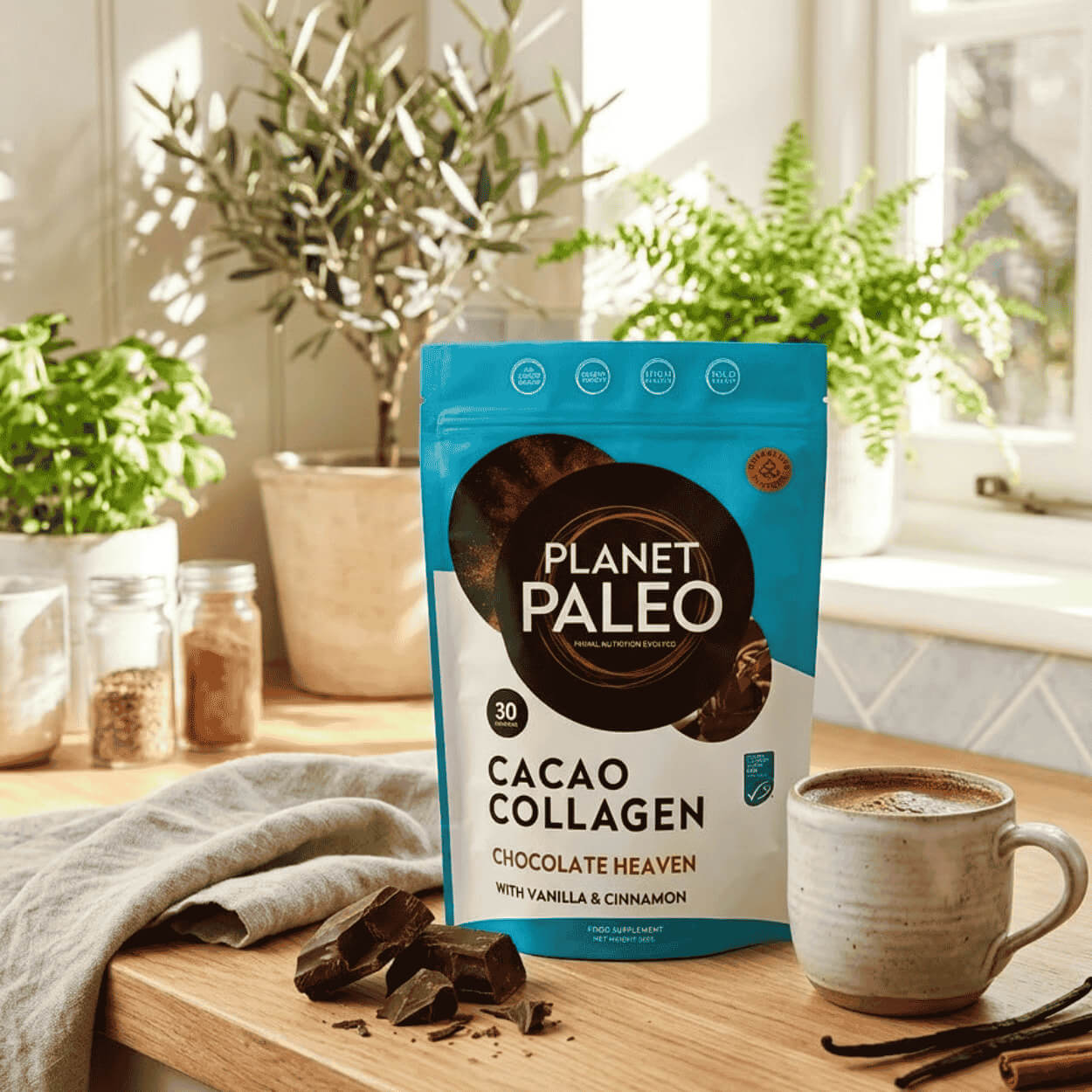 Balení čokoládového mořského kolagenu Planet Paleo vedle hrnku čokoládového nápoje a kousků čokolády.